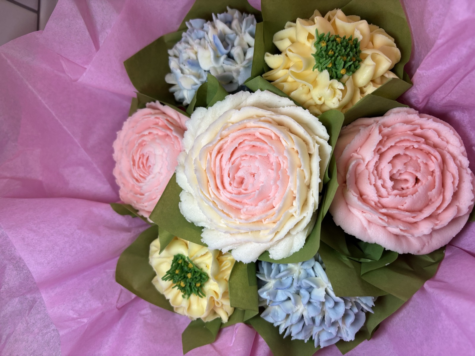 Pastel blooming cupcakes arranged as a colorful flower bouquet