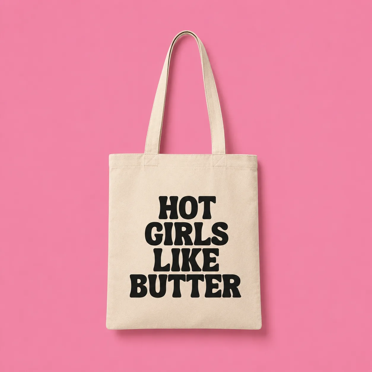 Cream canvas tote reading Hot Girls Like Butter on a pink background